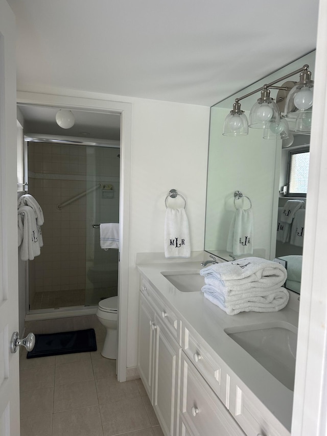 bathroom featuring tile patterned floors, toilet, a shower with shower door, and vanity