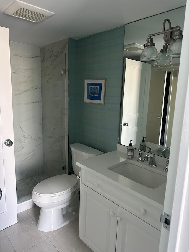 bathroom featuring vanity, toilet, and a tile shower