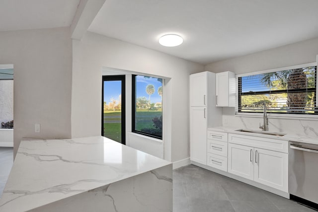 kitchen with light stone countertops, sink, stainless steel dishwasher, and white cabinets