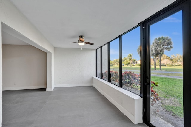 unfurnished sunroom featuring ceiling fan