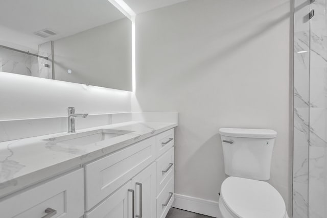 bathroom featuring vanity, an enclosed shower, and toilet