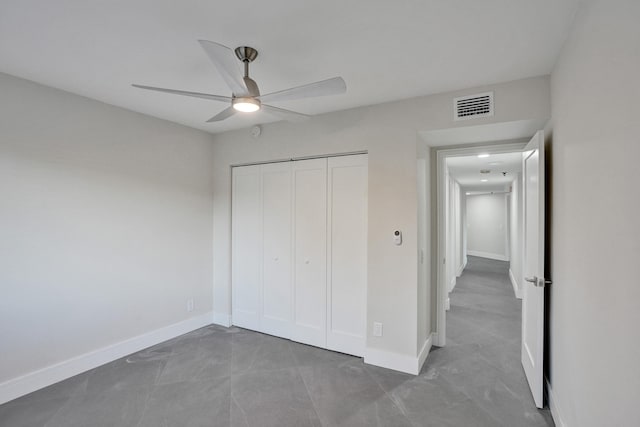 unfurnished bedroom with ceiling fan and a closet