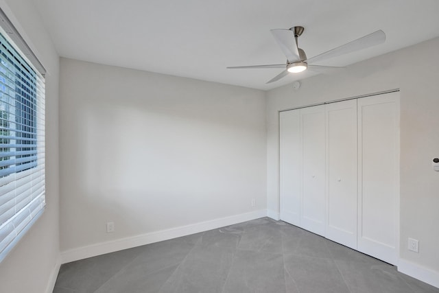 unfurnished bedroom featuring ceiling fan and a closet