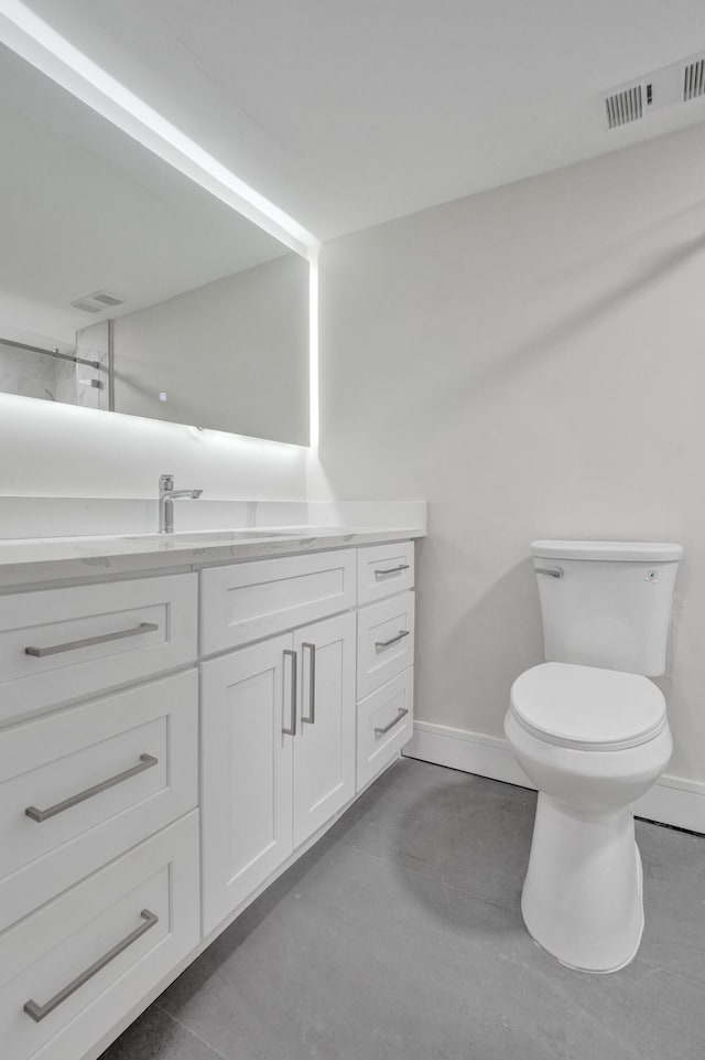 bathroom with vanity, concrete floors, and toilet