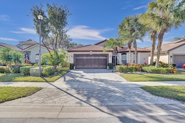 mediterranean / spanish home with a garage and a front lawn