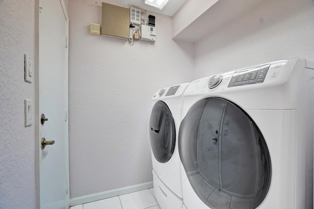 laundry room featuring washer and dryer and light tile patterned floors