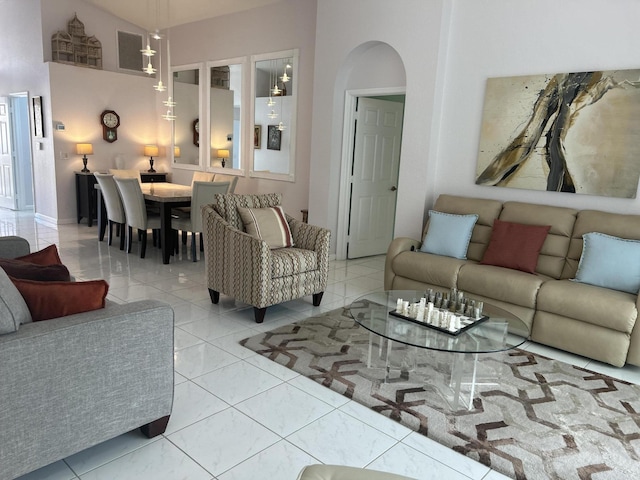 living room with light tile patterned floors and a high ceiling