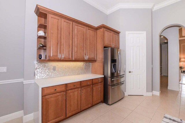9895 SW Nuova Way, Port Saint Lucie, FL 34986 - kitchen featuring tasteful backsplash, stainless steel refrigerator with ice dispenser, light tile patterned floors, and crown molding