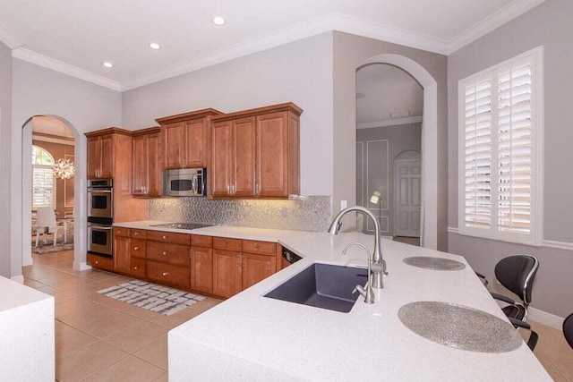 9895 SW Nuova Way, Port Saint Lucie, FL 34986 - kitchen featuring sink, crown molding, backsplash, stainless steel appliances, and light tile patterned flooring