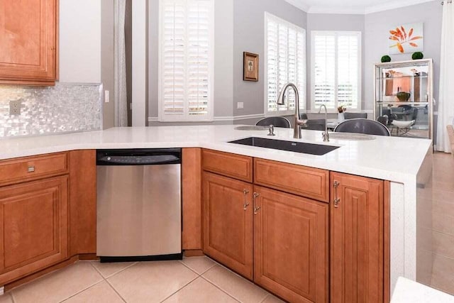 9895 SW Nuova Way, Port Saint Lucie, FL 34986 - kitchen featuring sink, light tile patterned floors, ornamental molding, stainless steel dishwasher, and kitchen peninsula