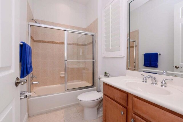 9895 SW Nuova Way, Port Saint Lucie, FL 34986 - full bathroom featuring tile patterned flooring, vanity, bath / shower combo with glass door, and toilet