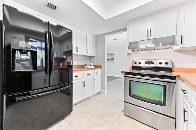 kitchen with stainless steel electric stove, freestanding refrigerator, decorative backsplash, wood counters, and under cabinet range hood