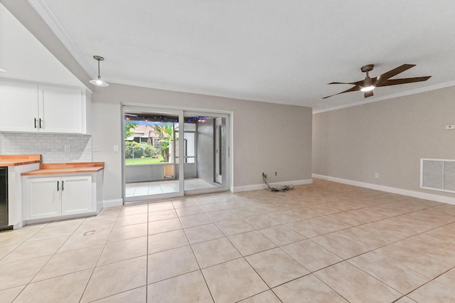 unfurnished living room featuring crown molding, ceiling fan, and light tile patterned flooring