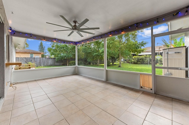 unfurnished sunroom with ceiling fan