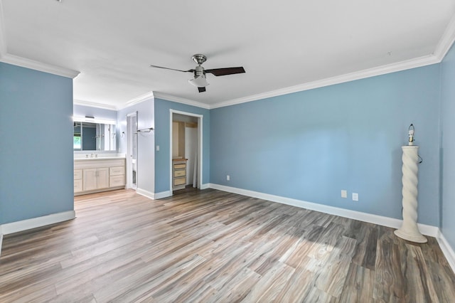 unfurnished bedroom with sink, crown molding, light hardwood / wood-style flooring, ceiling fan, and ensuite bathroom