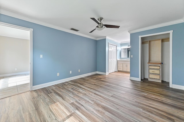 unfurnished bedroom featuring crown molding, hardwood / wood-style floors, ceiling fan, and ensuite bathroom