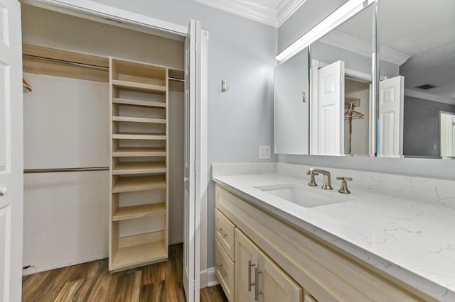 bathroom featuring hardwood / wood-style flooring, ornamental molding, and vanity