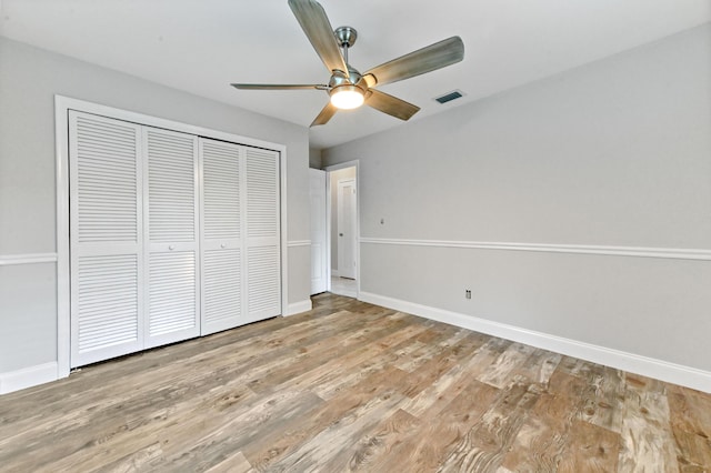 unfurnished bedroom with light hardwood / wood-style floors, a closet, and ceiling fan