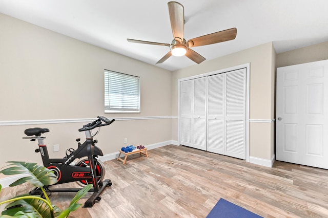 workout area with wood finished floors, a ceiling fan, and baseboards