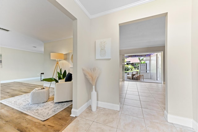 tiled entrance foyer with baseboards, visible vents, and ornamental molding