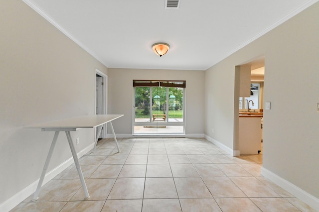 tiled spare room with sink and ornamental molding