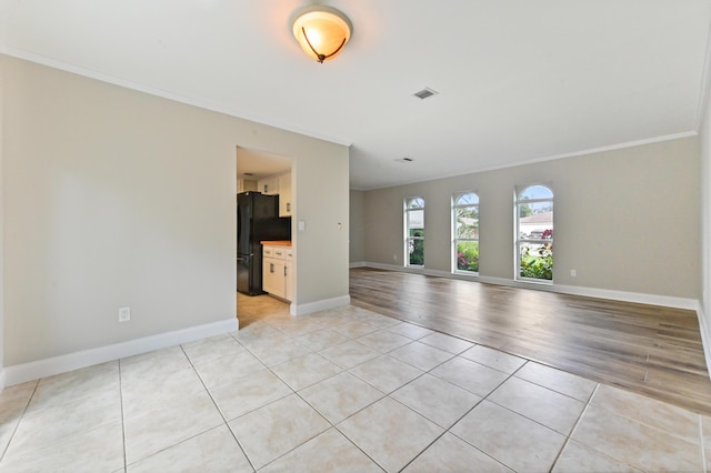 unfurnished living room featuring light tile patterned floors and crown molding