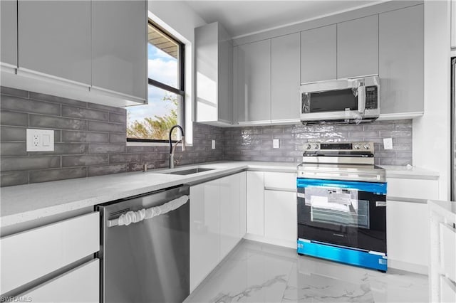 kitchen featuring stainless steel appliances, marble finish floor, a sink, and modern cabinets