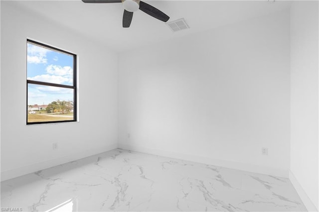 spare room featuring marble finish floor, a ceiling fan, visible vents, and baseboards