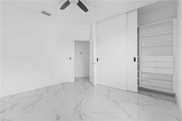 unfurnished bedroom featuring a ceiling fan, visible vents, baseboards, marble finish floor, and a closet