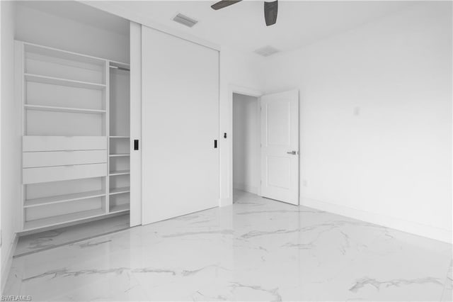 unfurnished bedroom featuring marble finish floor, a closet, visible vents, ceiling fan, and baseboards