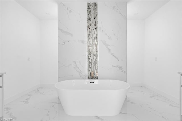 bathroom featuring a freestanding tub, baseboards, marble finish floor, and vanity