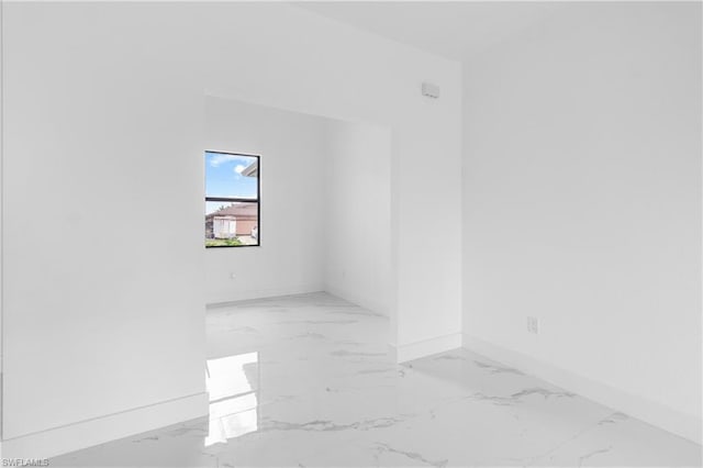 spare room with marble finish floor and baseboards