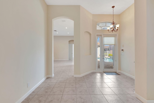 tiled entryway with a chandelier