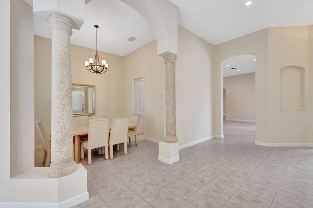 dining space with light tile patterned floors, decorative columns, and baseboards