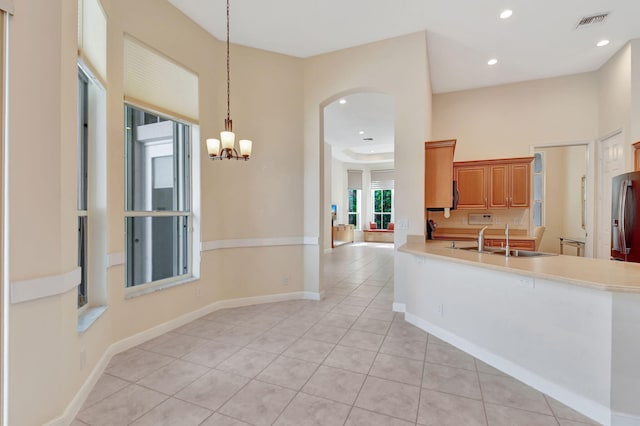 kitchen with a notable chandelier, decorative light fixtures, sink, and light tile patterned floors