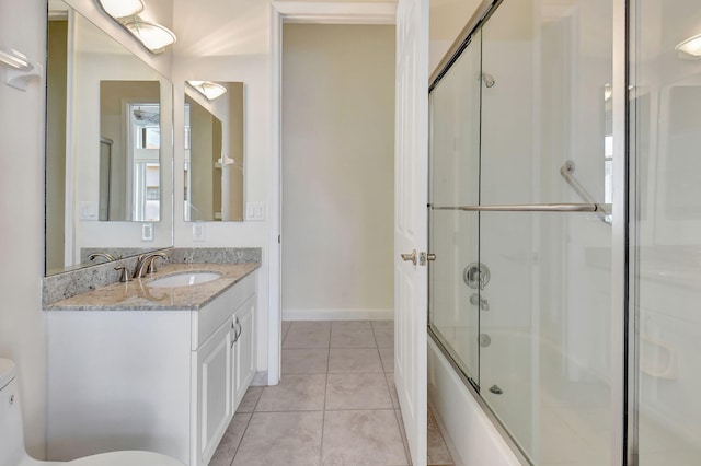 full bath with tile patterned flooring, toilet, shower / bath combination with glass door, vanity, and baseboards