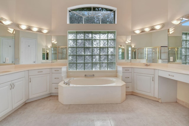 bathroom with vanity, separate shower and tub, a towering ceiling, and tile patterned floors