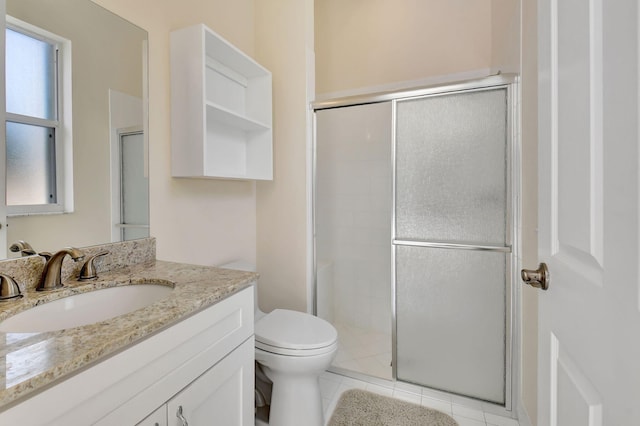 bathroom featuring vanity, toilet, a shower with shower door, and tile patterned flooring