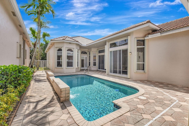 outdoor pool featuring fence and a patio