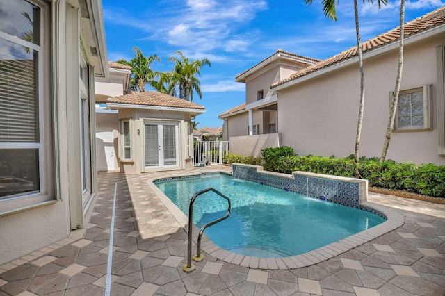 view of pool featuring a patio, pool water feature, and french doors