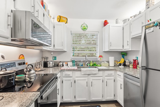 kitchen with light stone counters, white cabinets, appliances with stainless steel finishes, and a sink