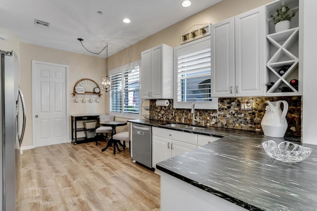 kitchen with a sink, visible vents, light wood-style floors, white cabinets, and appliances with stainless steel finishes