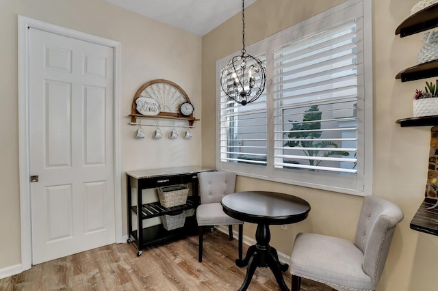 dining area featuring a notable chandelier, baseboards, and wood finished floors