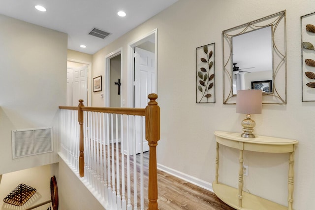 hall featuring recessed lighting, visible vents, an upstairs landing, wood finished floors, and baseboards