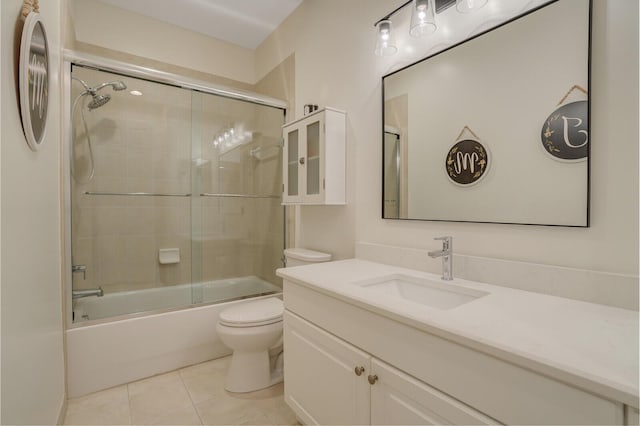 bathroom with vanity, combined bath / shower with glass door, tile patterned flooring, and toilet