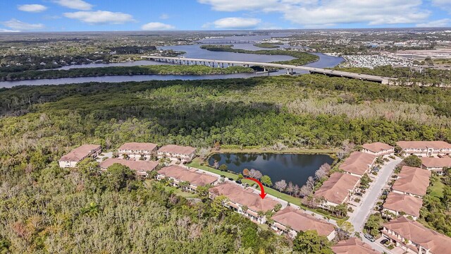 drone / aerial view with a water view and a wooded view