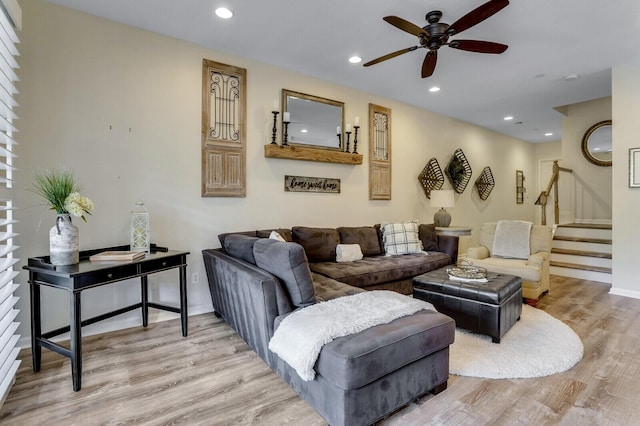 living area featuring baseboards, ceiling fan, stairway, light wood-style floors, and recessed lighting