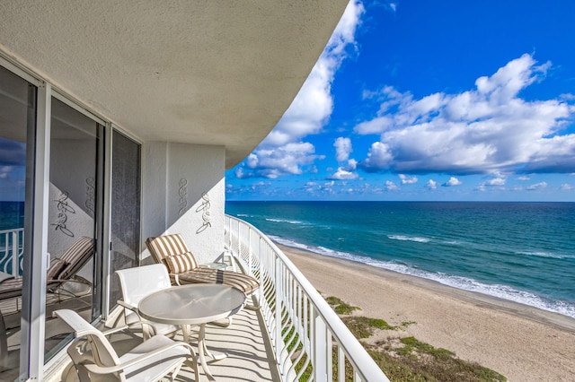 balcony featuring a water view and a beach view