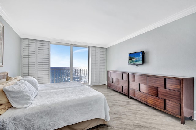 bedroom with a wall of windows, ornamental molding, access to outside, and light wood-type flooring