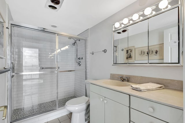 bathroom featuring vanity, toilet, a shower with shower door, and tile patterned flooring